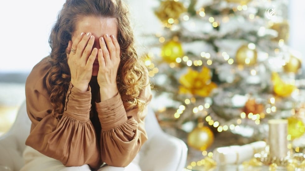 Frau Hände vor Gesicht, Stress vor Weihnachtsbaum